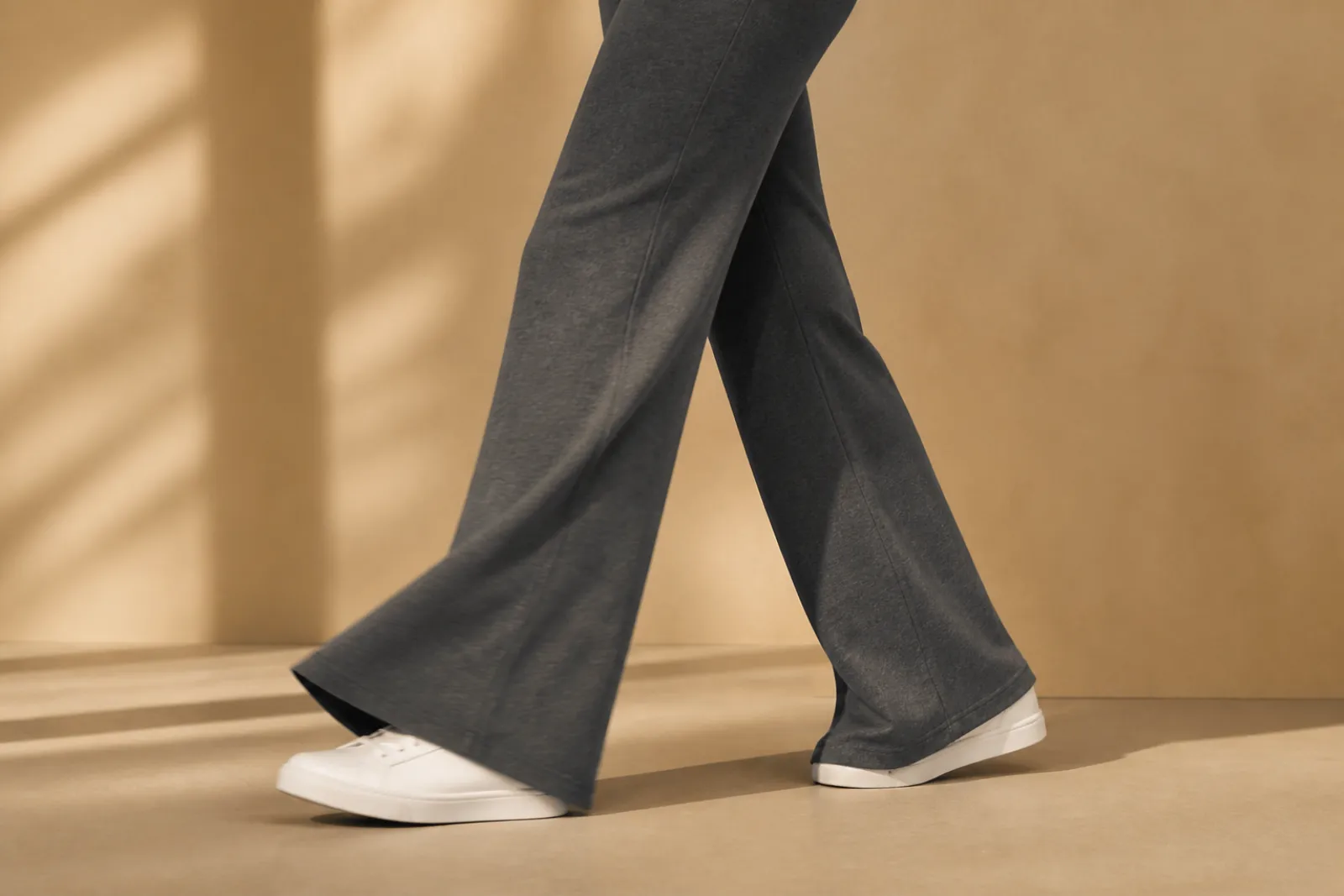 Flare sweatpants in motion, wide hem swinging over white sneakers